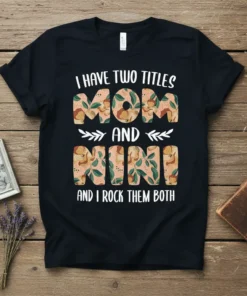 I Have Two Titles Mom and Nini And I Rock Them Both quote on a black t-shirt, featuring decorative lettering