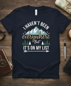T-shirt with the quote "I Haven't Been Everywhere But It's On My List" featuring mountains and trees graphic