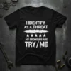 T-shirt with white distressed text reading "I IDENTIFY AS A THREAT" above stars and "MY PRONOUNS ARE TRY/ME"