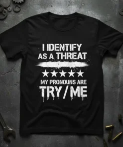 T-shirt with white distressed text reading "I IDENTIFY AS A THREAT" above stars and "MY PRONOUNS ARE TRY/ME"
