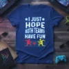 Blue t-shirt with white text "I JUST HOPE BOTH TEAMS HAVE FUN" and graphics of two running figures playing basketball