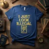 Blue t-shirt with yellow text "I Just Look Illegal" and a passport graphic, featuring a topographic map background