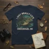 I Just Really Like Crocodiles, OK text with a detailed illustration of a crocodile in water on a navy blue