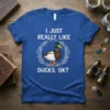 I JUST REALLY LIKE DUCKS, OK? text with a mallard duck graphic, white wreath, on a blue t-shirt