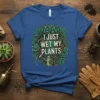 T-shirt with the text "I Just Wet My Plants" surrounded by lush green leaves and a watering can graphic