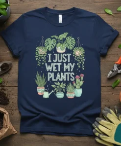Navy blue t-shirt with the text "I JUST WET MY PLANTS" surrounded by various potted and hanging houseplants and a