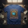 I KEEP ALL MY DAD JOKES IN A DAD-A-BASE text on a blue t-shirt with steampunk-inspired database graphic