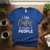 I Like Coffee & Maybe 3 PEOPLE quote on a royal blue t-shirt, featuring stylized text and a coffee cup