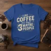 I Like Coffee And Maybe 3 People quote on a blue t-shirt, featuring vintage typography and coffee bean graphics
