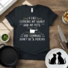 Black t-shirt with white text that reads "I like cooking my family and my pets. Use commas. Don't be a
