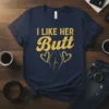 Navy t-shirt with distressed yellow text "I LIKE HER Butt" and a graphic of buttocks with two hearts
