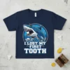 I Lost My First Tooth text on a navy t-shirt with a cartoon shark illustration, perfect for kids celebrating a