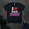 Black t-shirt with "I Love Bad Bitches" text and red heart graphic, featuring bold pink and blue lettering