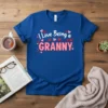 Blue t-shirt with "I Love Being a GRANNY" text in white and pink, surrounded by small hearts