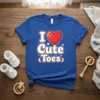 Blue t-shirt with "I Love Cute Toes" text and a red heart graphic, featuring baby feet icons and stars