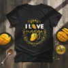 I LOVE mango text with two illustrated mango fruits inside a decorative golden floral wreath on a black t-shirt