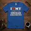 I Love My Psychotic Cougar Girlfriend text with a flaming heart graphic on a blue t-shirt
