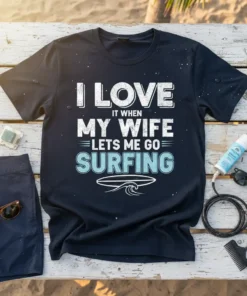 I Love It When My Wife Lets Me Go Surfing text with a surfboard and wave graphic on a navy
