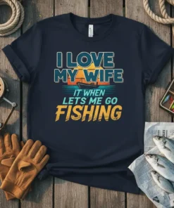 I LOVE MY WIFE IT WHEN LETS ME GO FISHING text design with sunset and boat graphic on navy t-shirt