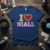 Blue t-shirt with yellow "I" and red gear heart, spelling "I Love Niall" in distressed pink and white letters