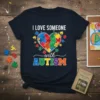 I Love Someone with Autism text and puzzle heart graphic on a navy blue t-shirt, autism awareness design