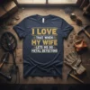 I LOVE THAT WHEN MY WIFE LETS ME GO METAL DETECTING text on a navy t-shirt, with metal detecting equipment