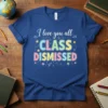 Teacher t-shirt with "I love you all CLASS DISMISSED" text in colorful, playful lettering, adorned with suns, flowers, and paper