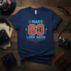 I Make 60 Look Good text with neon-style numbers and graphic elements on a navy t-shirt