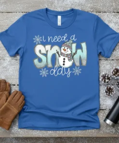 I Need A Snow Day t-shirt with a cute snowman graphic and glittery blue text