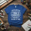 Blue t-shirt with white text: "I Never Question Tina's Choices Because I'm One of Them". Design includes art-related graphics like