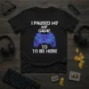 Black t-shirt with white text "I PAUSED MY MY GAME TO TO BE HERE" and a neon blue and purple