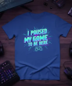 I Paused My Game To Be Here quote on a blue t-shirt with neon green and pink retro gaming graphics