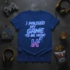 I Paused My Game To Be Here quote on a blue t-shirt, with glitch effect and pixelated graphic
