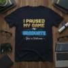 I Paused My Game To Graduate funny quote t-shirt with glowing blue circuit design and gold text