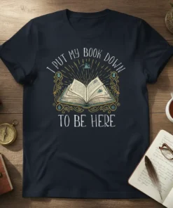 I Put My Book Down To Be Here quote on a dark navy t-shirt with an open book graphic