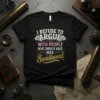 I Refuse to Argue With People Who Should Have Been Swallowed quote on a black t-shirt, featuring retro-style typography