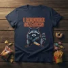 I Require Snacks T-Shirt with a cute raccoon holding a knife, glowing orange text, and snack-themed graphics