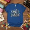 Blue t-shirt with "I Smell Fabric" text in decorative font, surrounded by sewing-themed elements