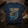 Blue T-Rex dinosaur wearing pilot goggles and scarf, text reads "I STIL ROOARR WITHOUT TONSILS" on a dark blue t-shirt