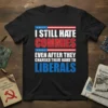 I STILL HATE COMMIES EVEN AFTER THEY CHANGED THEIR NAME TO LIBERALS text design on black t-shirt with American flag