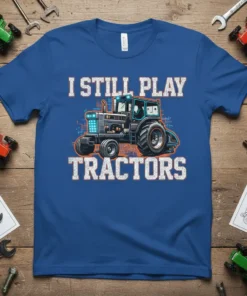 I Still Play Tractors t-shirt design featuring a detailed blue tractor graphic and distressed white lettering