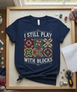 Navy t-shirt with "I Still Play With Blocks" text and colorful patchwork quilt squares design