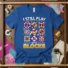 Blue t-shirt with "I Still Play With Blocks" text and colorful quilt block graphics