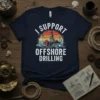 I SUPPORT OFFSHORE DRILLING text with an oil rig graphic and wind turbines, on a navy blue t-shirt