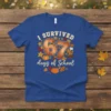 Blue t-shirt with "I SURVIVED 67 days of School" text, featuring pumpkins, leaves, and stars