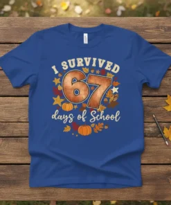 Blue t-shirt with "I SURVIVED 67 days of School" text, featuring pumpkins, leaves, and stars