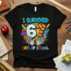 Black t-shirt with "I Survived 67 Days of School" text, colorful graphics, and handprints