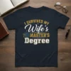 I Survived My Wife's Master's Degree text design with graduation cap graphic, white and gold lettering on navy t-shirt