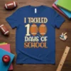 I Tackled 100 Days of School text with football graphics on a blue t-shirt, perfect for students and teachers