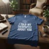 White text "I Told My Therapist About You" with a brain graphic on a blue t-shirt